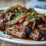 Savory Crock Pot French Onion Pot Roast simmering with wine sauce and sweet onions