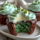 Festive green velvet cupcakes with cocoa undertones, topped with creamy cream cheese frosting for St. Patrick's Day celebrations.