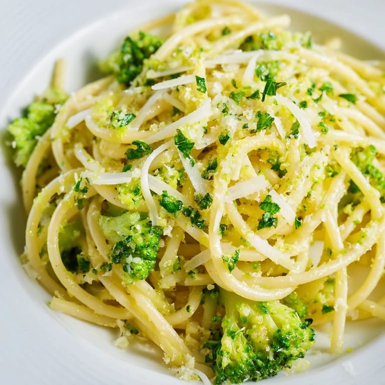 A rustic skillet of One-Pot Lemon Broccoli Pasta features vibrant green broccoli florets and glossy garlic sauce.