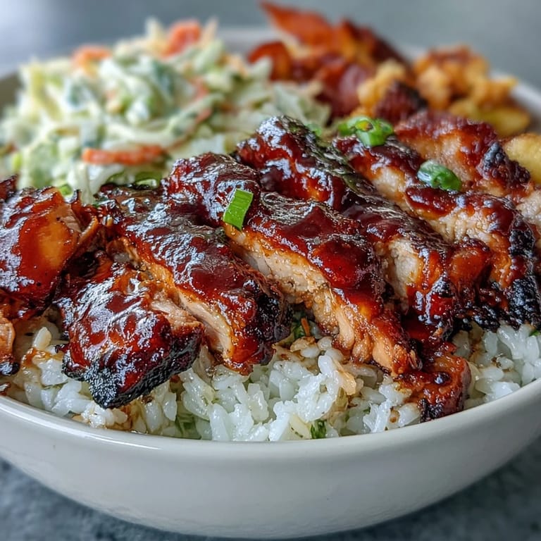 Golden BBQ chicken pieces atop a hearty rice base, garnished with fresh coleslaw and paprika roasted vegetables.