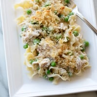Freshly baked Tuna Casserole emerges from the oven with golden panko crumbs, peas, and tender noodles peeking through creamy sauce. 