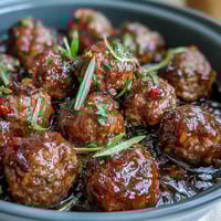 Tender Slow Cooker Peach Glazed Meatballs glistening with chunky peach preserves and chili sauce, served hot from the slow cooker.