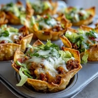 Golden crispy wonton cups brimming with seasoned taco filling and melted cheese.